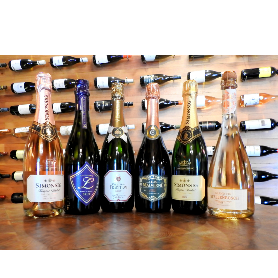 A Rosé Mixed Case of six sparkling wine bottles on a wooden table.
